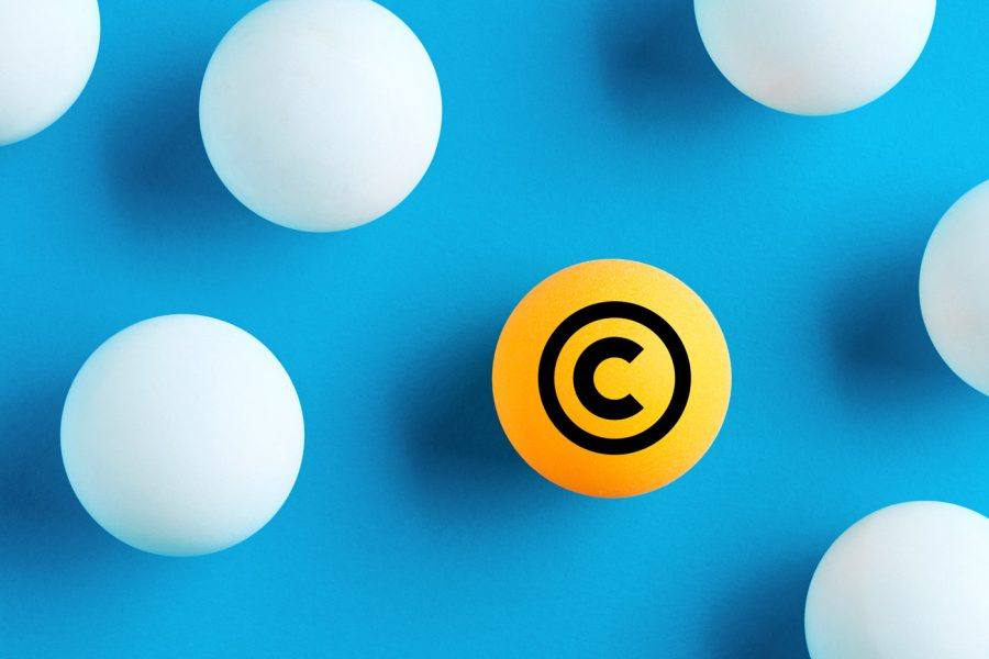 كرة برتقالية تحمل رمز حقوق الطبع والنشر بين الكرات البيضاء على خلفية زرقاء